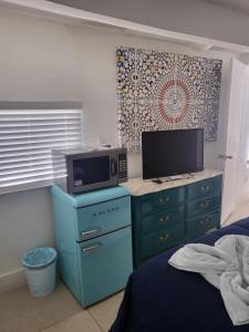 a bedroom with a tv and a desk with a microwave at 1161 Studio 2 Main Miami in Miami