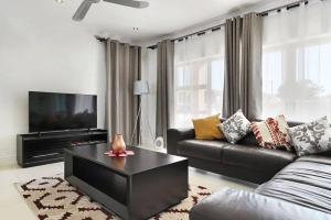 sala de estar con sofá y TV en Prestigious Guest Villa, en Ciudad del Cabo