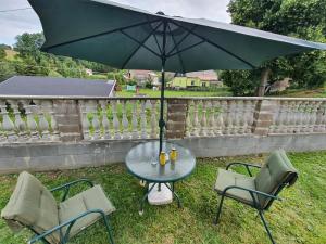a table and two chairs with an umbrella in the grass at CARPE DIEM in Ryžoviště