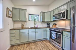 a kitchen with green cabinets and a stove top oven at Updated Lakefront Cabin with Deck and Boat Dock! in Eucha
