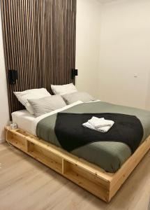 Cette chambre comprend un grand lit avec un cadre en bois. dans l'établissement LE-Host, à Leipzig