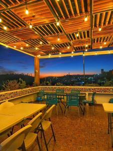 un patio con mesas, sillas y luces en Hotel Maggic Home Panorámica en Guanajuato