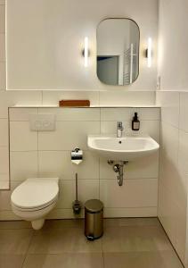 uma casa de banho com um WC, um lavatório e um espelho. em LE-Host em Leipzig