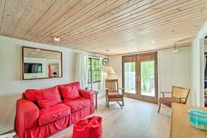uma sala de estar com um sofá vermelho e uma mesa em Charming Horicon Cottage and Dock on Rock River em Juneau