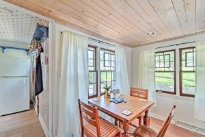 a dining room with a table and chairs and a refrigerator at Charming Horicon Cottage and Dock on Rock River in Juneau