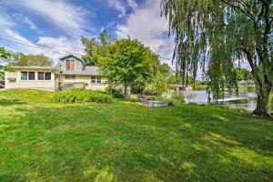 a house with a large yard next to a lake at Peaceful Horicon Studio with Rock River Access! in Juneau