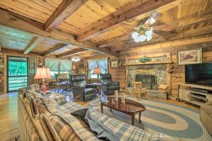 a living room with a couch and a fireplace at Scenic Creekside Cabin with Wraparound Porch! in Highlands