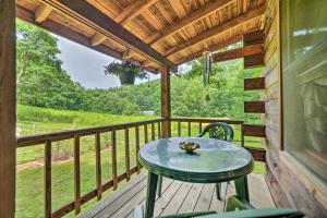 a table on the porch of a cabin at Scenic Creekside Cabin with Wraparound Porch! in Highlands