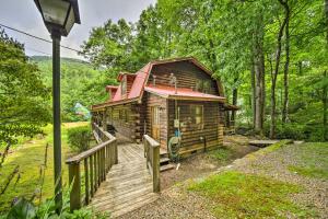 a cabin in the woods with a wooden deck at Scenic Creekside Cabin with Wraparound Porch! in Highlands