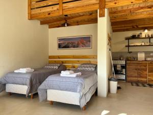 two beds in a room with wooden ceilings at Chaltén Mountain Lofts 2 in El Chalten