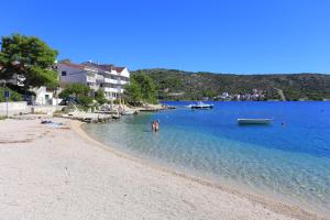 a group of people in the water on a beach at Apartments by the sea Rogoznica - 3262 in Rogoznica