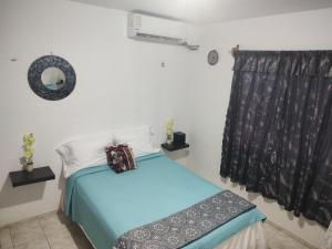 a bedroom with a blue bed and a window at La casa Jorge & Marvin in Cancún
