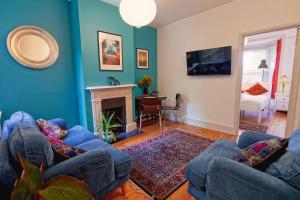 a living room with two blue couches and a fireplace at Boscobel Apartments Down in Winchester