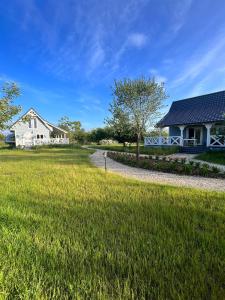 a house and a yard with a grass field at Joniec Świata - 2 domy na wyłączność in Joniec