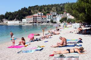 a group of people laying on a beach at Apartments by the sea Drvenik Donja vala, Makarska - 6701 in Drvenik