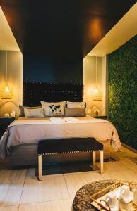 Schlafzimmer mit einem großen Bett mit einer Bank in der Unterkunft LG Golden Suites in San Miguel de Tucumán