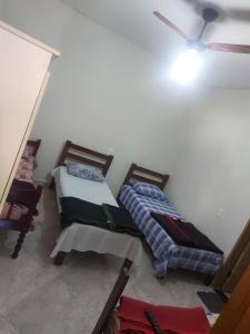a bedroom with two beds and a ceiling at Pousada Tropical in Aparecida