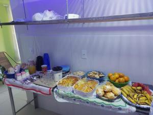 a table with many different types of food on it at Pousada Tropical in Aparecida