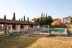 uma piscina num quintal com cadeiras e um pavilhão em Borgo La Casa em Montaione