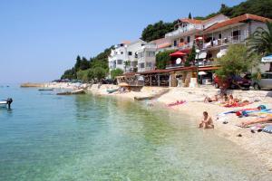 eine Gruppe von Menschen an einem Strand in der Nähe des Wassers in der Unterkunft Apartments by the sea Zaostrog, Makarska - 6659 in Zaostrog