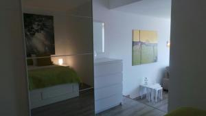 sypialnia z łóżkiem i komodą z lustrem w obiekcie Ventur Balcony w Caniço