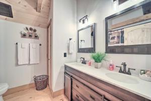a bathroom with a sink and a toilet and a mirror at Luxe Log Cabin with Modern Finishes and Mtn Views in Maggie Valley +22 photos