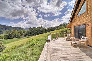 a wooden deck with benches on a house at Luxe Log Cabin with Modern Finishes and Mtn Views in Maggie Valley