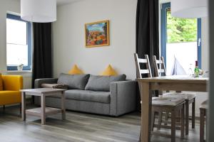 uma sala de estar com um sofá e uma mesa em Appartementhaus Alter Speicher em Klink