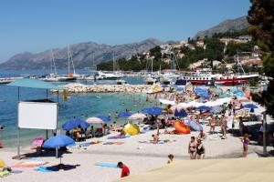 a group of people on the beach at a beach at Apartments by the sea Baska Voda, Makarska - 6848 in Baška Voda