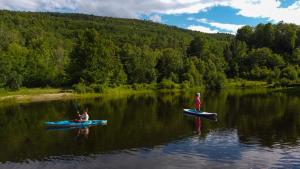 two people in kayaks on a lake at La Bohémienne des yourtes du petit ruisseau in Mandeville