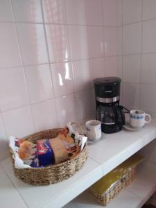 a shelf with a coffee maker and a basket of food at A Lau' De Los Álamos in Humahuaca