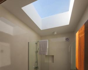 ein Dachfenster im Bad mit Dusche in der Unterkunft Casa dos Romeiros in Santa Bárbara