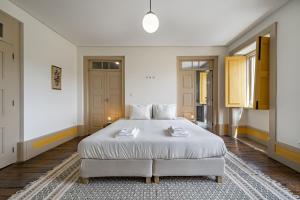 a bedroom with a large bed with white sheets at Nomad's Country - 4BED Casa de Macieira in Santa Maria Da Feira
