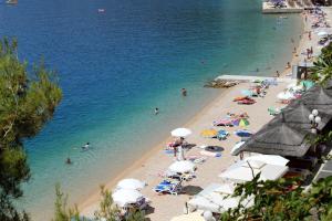 una spiaggia con un gruppo di persone in acqua di Apartments by the sea Podgora, Makarska - 2615 a Podgora