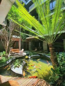 a koi pond with a palm tree in a building at Minh Boutique in Da Nang