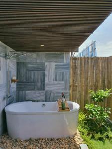 a bath tub sitting under a roof in a bathroom at Minh Boutique in Danang