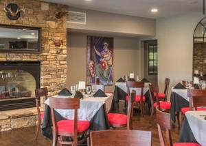 a restaurant with tables and chairs and a fireplace at Peaceful treetop escape! Pool table, grill, games, sleeps 10! in Helen