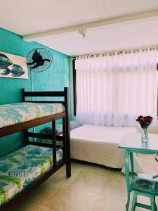 a bedroom with two bunk beds and a table at Hostel e Pousada Bahia Beach in Itanhaém +96 photos
