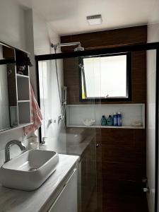 a bathroom with a sink and a window at Apt perto da praia com vaga e serv de arrumadeira in Rio de Janeiro
