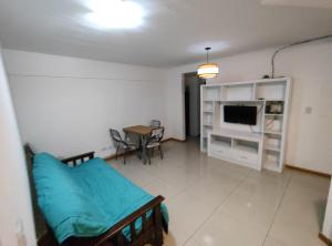 Habitación con cama, mesa y TV. en Departamento completo en Rosario