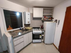 a small kitchen with a stove and a refrigerator at Departamento completo in Rosario