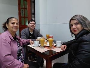 un grupo de personas sentadas en una mesa con bebidas en Hotel Real Bolivar, en Chimbote