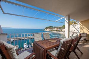 ein Balkon mit einem Holztisch und Stühlen in der Unterkunft Apartments by the sea Podgora, Makarska - 11469 in Podgora