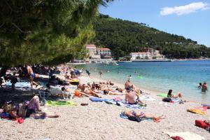 a group of people laying on a beach at Apartments by the sea Drvenik Donja vala, Makarska - 11553 in Drvenik