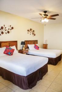 Habitación de hotel con 2 camas y ventilador de techo. en Nico Hotel en Antigua Guatemala