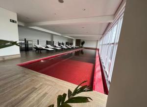 um quarto amplo com um tapete vermelho e uma janela grande em QS Marista - Studio Alessandra Antonelli - flat 1701 em Goiânia