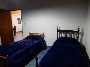 a bedroom with two beds and a hallway at del PARANA in Corrientes