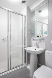 a bathroom with a shower and a sink and a toilet at George Hotel in Hexham