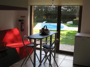 a table with a bowl of fruit on it next to a window at Quinta Sul America in Moimenta da Beira
