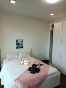 een slaapkamer met een wit bed met een bord erop bij C0503 Almas suites NETFLIX!100mbps BySTAY in Nusajaya